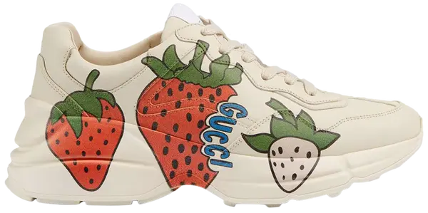 Gucci women’s Rhyton sneaker in white leather featuring oversized Gucci Strawberry graphic and chunky retro sole.

