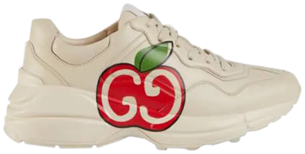 aGucci Wmns Rhyton sneaker in ivory leather featuring red GG Apple motif and thick rubber sole.

