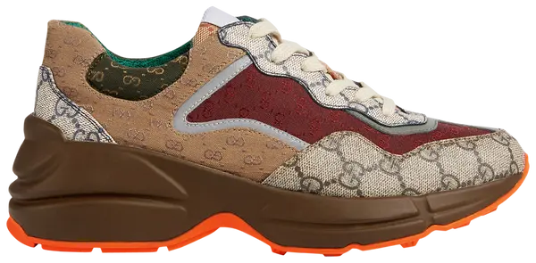 Gucci Wmns GG Rhyton sneaker in beige GG Supreme canvas with brick red Gucci logo and thick vintage-style rubber sole.

