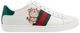 Doraemon x Gucci Wmns Ace ivory leather sneaker featuring Devil Doraemon patch, green-red Web stripes, and metallic heel accents.