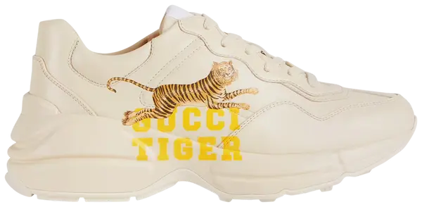 Gucci Wmns Rhyton 'Gucci Tiger' sneaker featuring retro tiger print on ivory leather upper with chunky sole.

