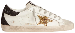 Golden Goose women's Superstar sneaker with gold star, black heel tab, and distressed white leather upper.